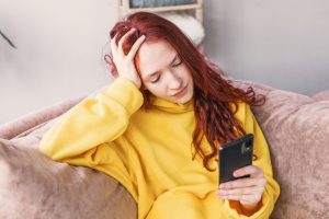 Frustrated sad teen girl on sofa at home