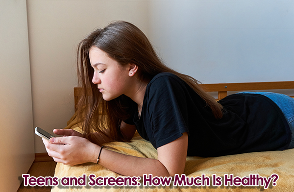 Depressed teenage girl looking at her phone on a bed. Text overlay says, "Teens and Screens: How Much Is Healthy?"