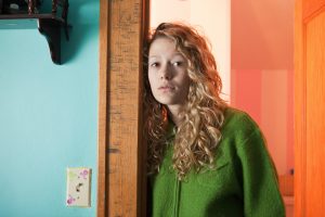 Teenage girl leaning in doorway, portrait