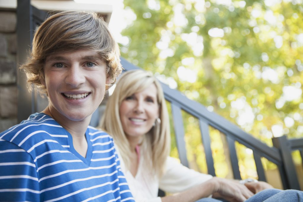 Portrait of happy mother and son sitting on porch Portrait of happy mother and son sitting on porch