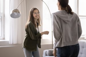 Happy adolescent girl dancing to energetic music with mother