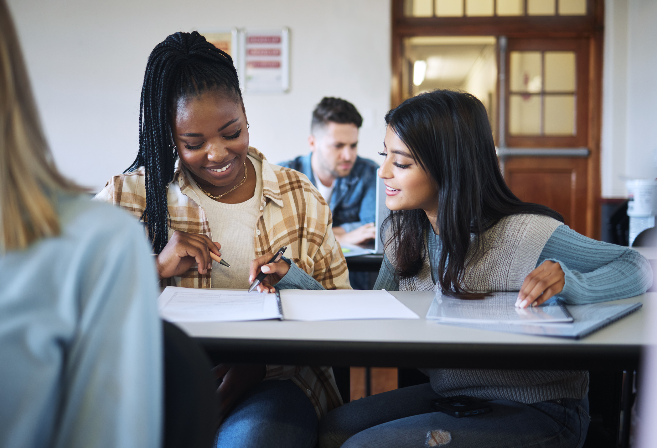 Education, teamwork or students in classroom for working together on university, college or school research project. Diversity, smile or happy friends learning, knowledge study or writing in notebook
